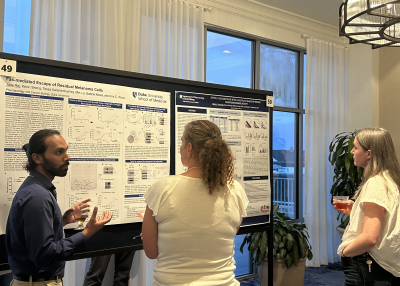 Jude Raj animatedly discusses his poster with colleagues.